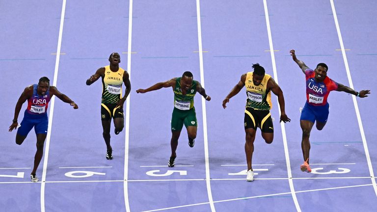 Lyles (L) crosses the finish line in the men's 100m final 