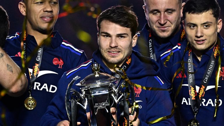 Injured France captain Antoine Dupont lifted the Six Nations trophy after Saturday's title-winning victory over Scotland