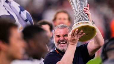 Tottenham's head coach Ange Postecoglou celebrates with the trophy