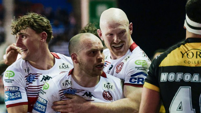 Liam Marshall (centre) celebrates a try with Noah Hodkinson (left) and Liam Farrell (right) in Wigan's win over York