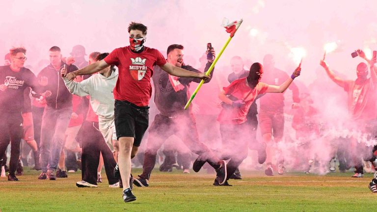 Die Anhänger von Slavia stürmen mit Pyro-Fackeln auf den Rasen.