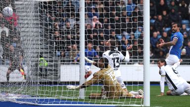 Lyndon Dykes of Millwall fails to stop a shot from Marlon Pack of Portsmouth