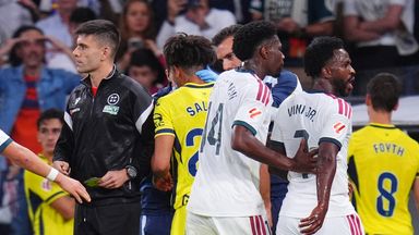 Real Madrid's Vinicius Junior, right, leaves the pitch after being shown a red card